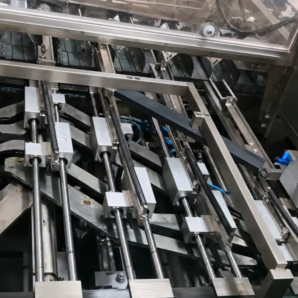 Continuous motion barrel cam loader on sachet cartoning machine